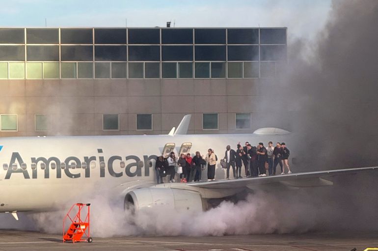 Passengers evacuate after American Airlines plane catches fire in ...