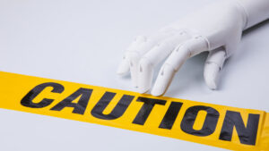 robotic hand with yellow caution tape (concept of AI as a threat to humanity)
