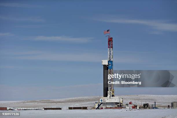 An American flag flies on top of a Unit Drilling Co. rig in the ...