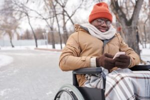 African disabled man typing a message on mobile phone while ...