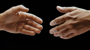 Close-up of two hands reaching towards each other
